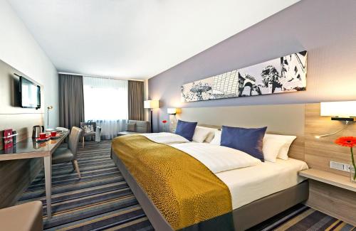 慕尼黑慕尼黑市北莱昂纳多酒店的配有一张床和一张书桌的酒店客房