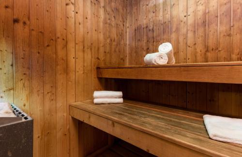 罗马Leonardo Boutique Hotel Rome Termini的一间带木墙、架子和毛巾的桑拿浴室