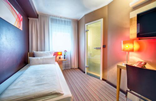 慕尼黑慕尼黑莱昂纳多精品酒店的酒店客房,配有床和电视