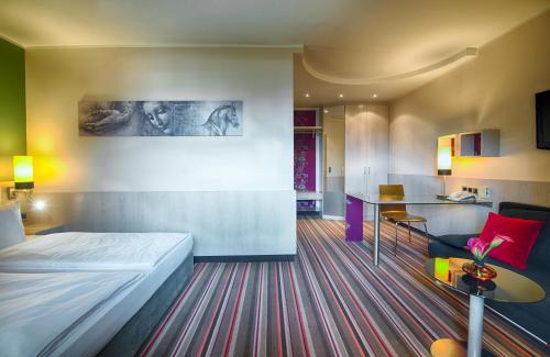 慕尼黑慕尼黑莱昂纳多酒店的酒店客房配有一张床铺和一张桌子。