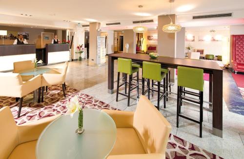 汉诺威汉诺威机场莱昂纳多酒店的酒店大堂设有酒吧和椅子