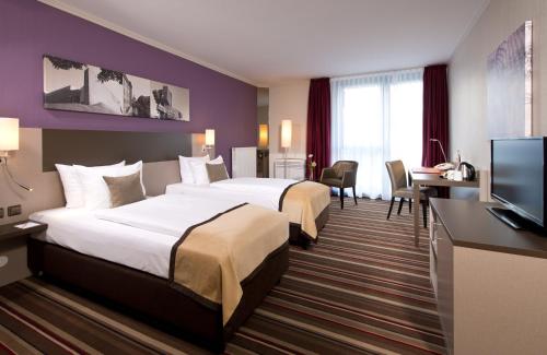 汉诺威汉诺威机场莱昂纳多酒店的酒店客房设有两张床和一台平面电视。