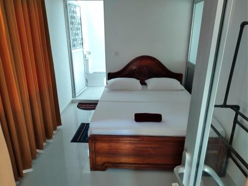 坦加拉Sandhara Home Stay的一间卧室设有一张床和一个窗口