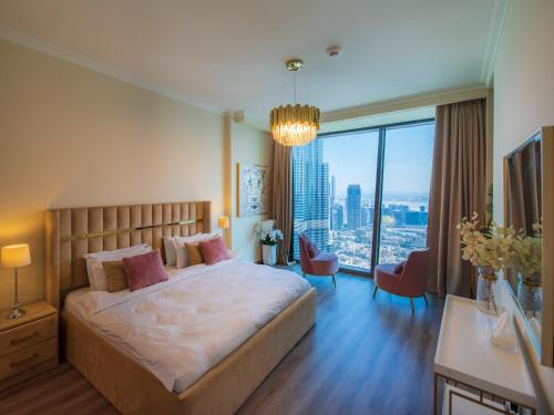 迪拜WORLD CLASS 3BR with full BURJ KHALIFA and FOUNTAIN VIEW的一间卧室设有一张大床和一个大窗户