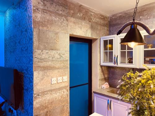 Riyadh Al Khabraبيتي بلس للغرف الفندقية- مدخل مستقل的厨房设有蓝色的门和安达灯