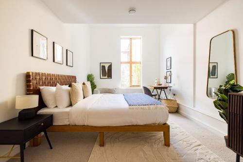 伦敦The Clapham Dream - Captivating 3BDR with Garden & Parking的白色卧室配有床和镜子