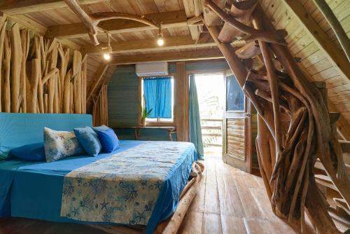 拉斯加勒拉斯CHALET TROPICAL Hotel & Restaurante的小木屋内一间卧室,配有一张蓝色的床
