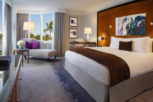 迈阿密普尔曼迈阿密机场酒店的酒店客房带一张大床和一把椅子