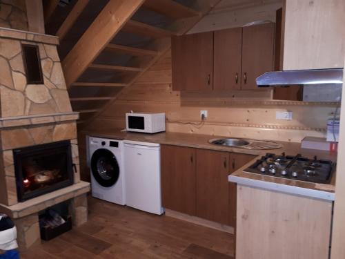 新塔尔格Domek w górach pod Jodłami的厨房配有炉灶、洗衣机和烘干机