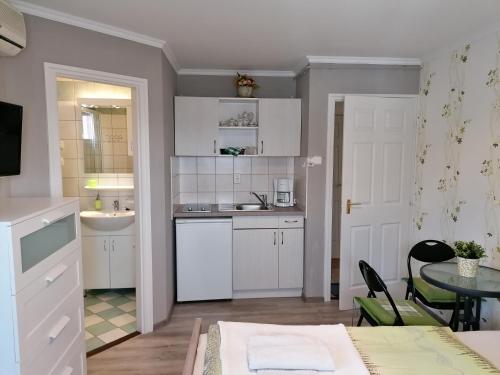 巴拉顿菲赖德维罗妮卡别墅的厨房配有白色橱柜、桌子和水槽。