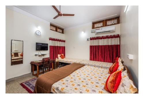 贾巴尔普尔Jaiswal Homestay的一间卧室配有一张床、一张桌子和一面镜子