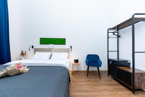 布达佩斯Adagio Downtown Rooms的一间卧室配有一张床和一张蓝色椅子