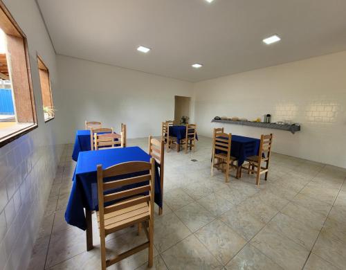 圣罗克迪米纳斯Canastra Eco Hospedagem的一间配备有蓝色桌子和椅子的用餐室