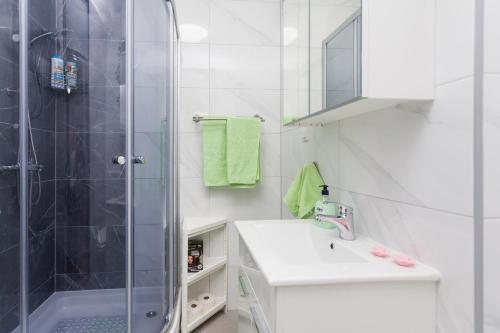 奥西耶克Apartman Lariva的带淋浴和盥洗盆的白色浴室