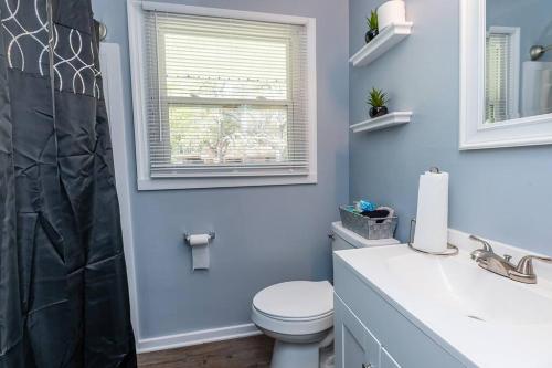 查尔斯顿Adorable Blue Little House的一间带卫生间、水槽和窗户的浴室