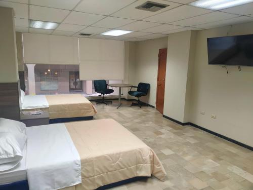 瓜亚基尔OCEANIk SUITES & HOTEL的酒店客房设有两张床和一台平面电视。