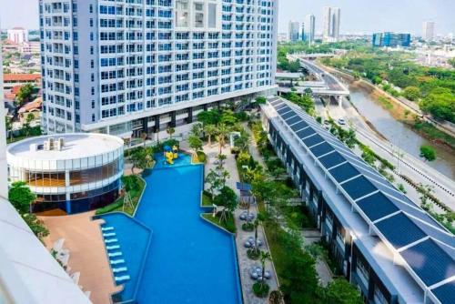 雅加达Studio Apartment at Puri Mansion West Jakarta的享有带游泳池的大型建筑的空中景致