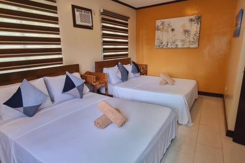 长滩岛Balay sa bukid (1bedroom)的一间设有两张带白色床单的床的房间