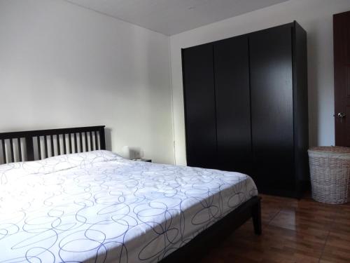 勒莫尔尼View on Ilot Fourneau的一间卧室配有一张床和一个黑色橱柜