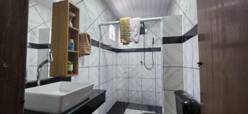 伊塔卡雷Casa Abade - 4 Quartos - Excelente localização的浴室配有白色水槽和淋浴。