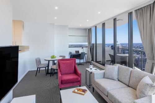 悉尼Meriton Suites Kent Street, Sydney的客厅配有沙发和桌子