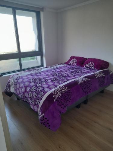 维纳德马Departamento en Viña del Mar的带2扇窗户的客房内的紫色床