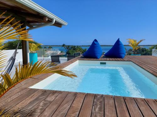 拉戈莱特Les Terrasses du Bénitier的木质甲板上的带蓝色枕头的游泳池