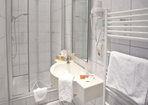 菲林根-施文宁根Hotel Bären的白色的浴室设有水槽和淋浴。