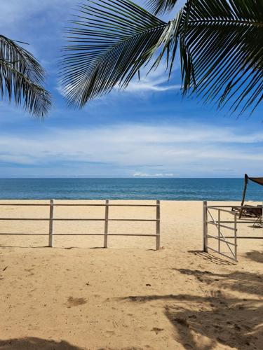 阿鲁甘湾Etnico Surf Resort的沙滩上,有栅栏和海洋