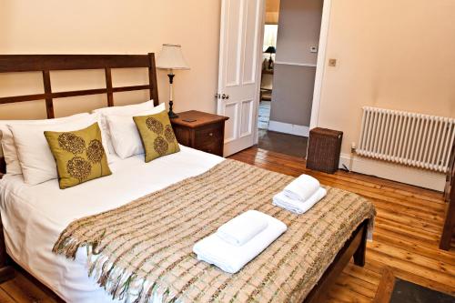 爱丁堡哈丁顿广场公寓的一间卧室配有一张床,上面有两条毛巾