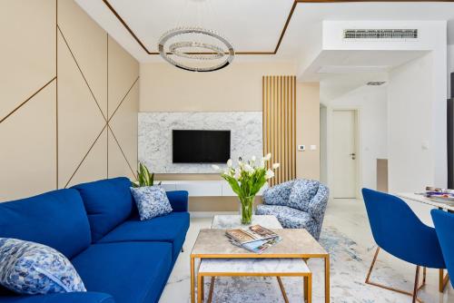 蒂瓦特Moderna Luxury Apartments with HEATED pool的客厅配有蓝色的沙发和椅子