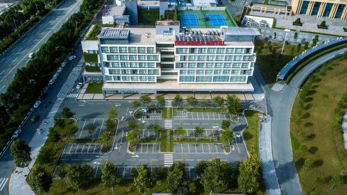 土龙木市Becamex Hotel New City的享有酒店大楼的顶部景色,设有停车场