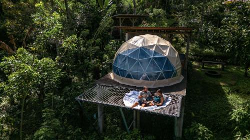 塔巴南Bali Jungle Camping by Amerta Experience的一群人坐在圆顶帐篷的桌子上