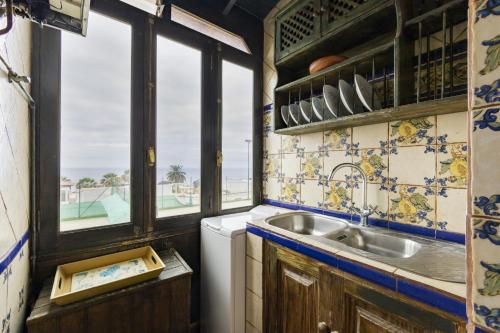 洛斯雷亚莱霍斯Bonito y acogedor apartamento con terraza的厨房设有水槽和窗户。