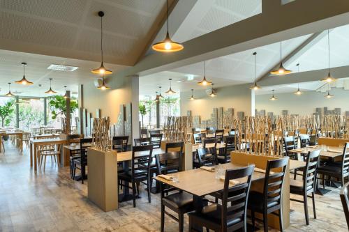 博德森特克欧里米尔温泉 - 布雷扎酒店的用餐室配有木桌和椅子