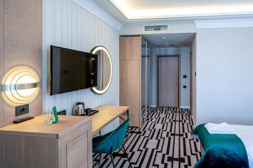 克利默内什蒂Hotel Carolin的配有一张床和一台平面电视的酒店客房