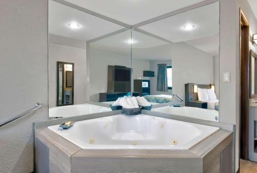 锡达拉皮兹锡达拉皮兹机场6号汽车旅馆的一个带大镜子的房间内的大浴缸