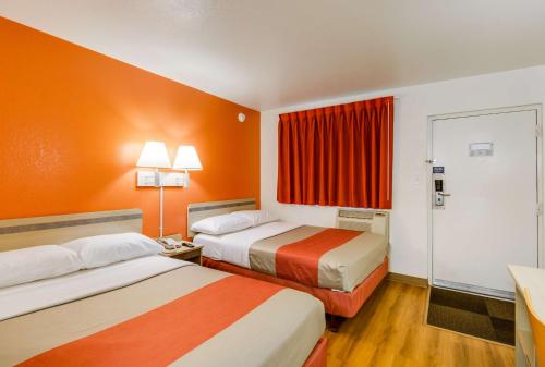 席勒公园芝加哥奥黑尔6号汽车旅馆-席勒公园的酒店客房,设有两张带橙色墙壁的床