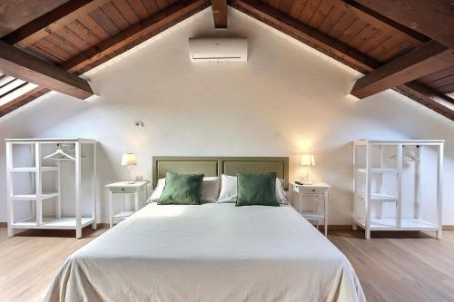 帕维亚卡西内托公寓式酒店的一间卧室配有一张带两个白色架子的大床