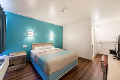 德尔里奥德尔里奥6号汽车旅馆的一间卧室设有一张床和蓝色的墙壁