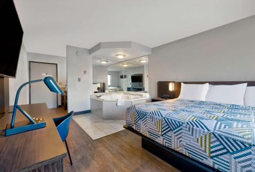 橡树溪橡树溪6号汽车旅馆的酒店客房配有一张床和浴缸。