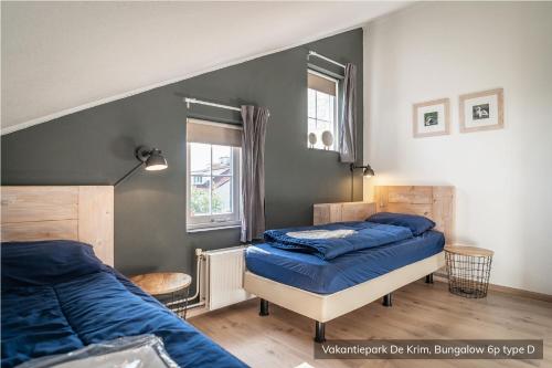 德科克斯多普克瑞姆特克塞尔度假公园的一间卧室配有两张带蓝色床单的床