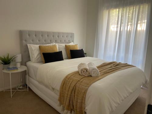 凯阿玛Kiama Palms on Terralong的卧室配有带毛巾的大型白色床