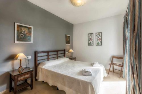 内尔哈齐蒙普拉亚公寓的一间卧室配有一张床和两张桌子及两张椅子