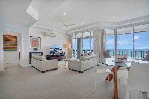 黄金海岸布罗德海滩奥希阿纳酒店的客厅配有白色家具和玻璃桌