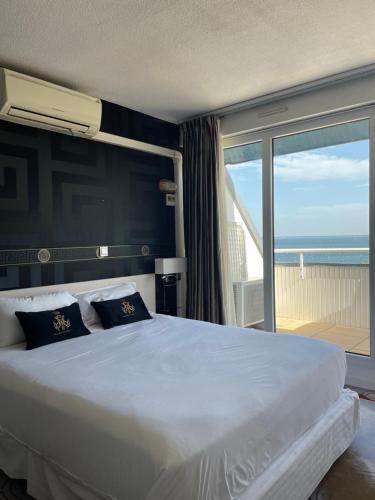 阿卡雄Appart'hôtel Le Trianon的一间卧室设有一张大床,享有海景
