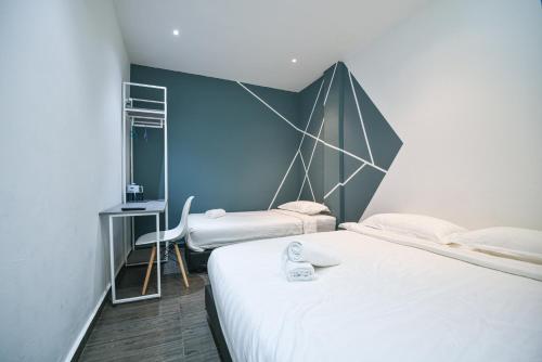 吉隆坡Meta Hotel的一间卧室设有两张床和蓝色的墙壁
