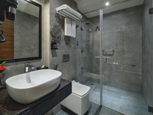 钦奈Essentia Premier Hotel Chennai OMR的浴室配有白色水槽和淋浴。