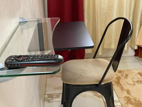 罗得城More Than Beauty Properties的一张带椅子的玻璃桌和一个遥控器