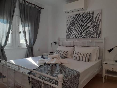 帕诺尔莫斯斯科派洛斯Villa Tillia的卧室配有白色的床和床头板